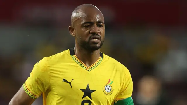 Jordan Ayew, vêtu d'un maillot jaune du Ghana et d'un brassard de capitaine vert sur le biceps gauche