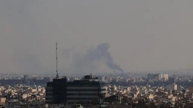 テヘランを俯瞰で撮影した写真。遠くで黒煙が上がっている