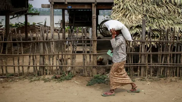 မုံရွာမှာ ကုလသမဂ္ဂက ဖြန့်ဝေတဲ့ ဓာတ်မြေသြဇာအိတ်ကို သယ်လာတဲ့ဒေသခံအမျိုးသမီးတစ်ဦး 