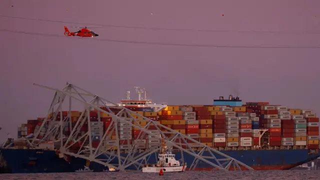 Вертолет летает над судном Dali, врезавшимся в мост в Балтиморе