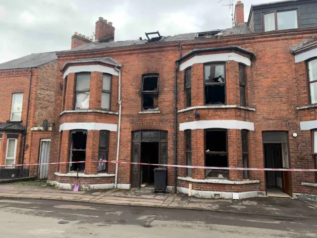 Двухэтажное здание с выбитами окнами и следами пожара.