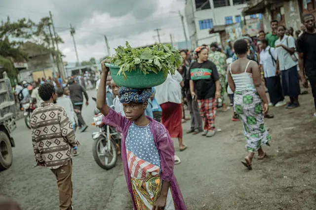 Une jeune fille vend des légumes près du lieu de rencontre du M23 et des habitants à Goma en octobre 2025.