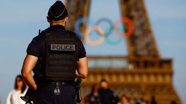 Policialgeração midas roletafrente a Torre Eiffel, que está decorada com os arcos olímpicos