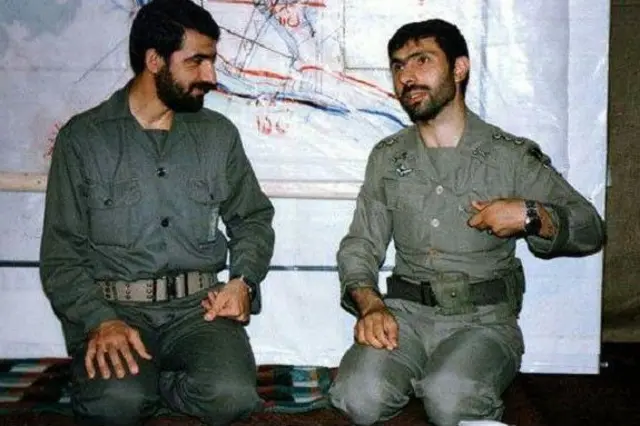 محسن رضایی و علی صیاد شیرازی در کنار هم روی زمین نشسته‌اند