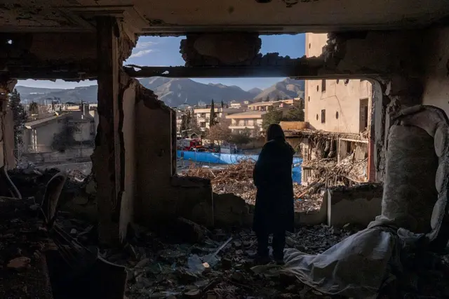 Una mujer observa el exterior este sábado desde su apartamento destruido en los restos de un edificio residencial y comercial en el barrio de Shahrak-e Gharb en Teherán, alcanzado el 16 de marzo durante los ataques de EE.UU. e Israel.