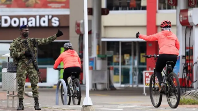 militar na rua e pessoas andandoalfcasinobicicleta