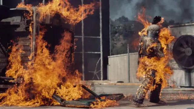 一張照片顯示基蒂·奧尼爾在其中一場特技表演中，走過一片被火焰吞噬的場地（8/11/1977）