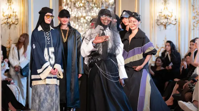 Fransız bir tasarımcı ve yanında üç model uzun elbiseler giymişler