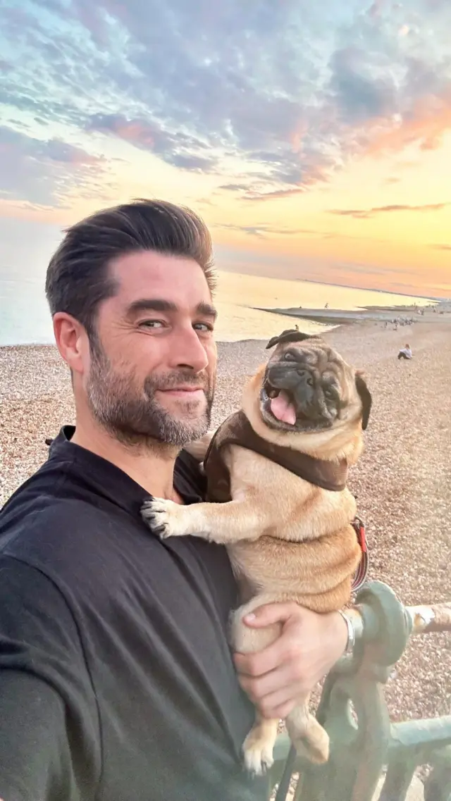 Matt Johnson and pug Alan Shearer on the beach at sunset