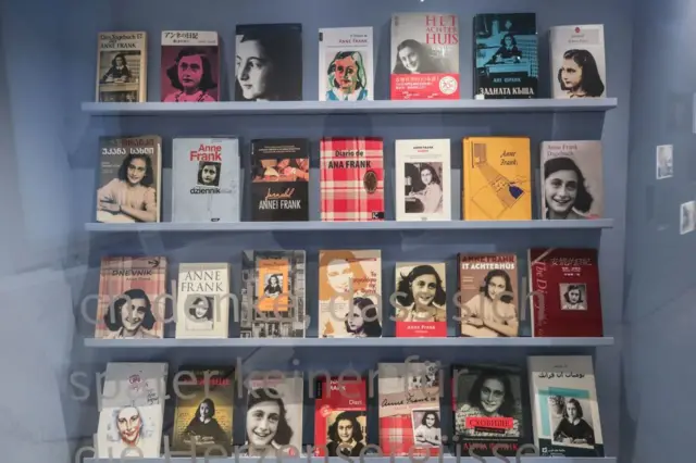 Una estantería que muestra distintas ediciones del diario de Ana Frank.