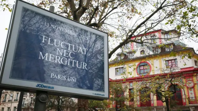 Uma placa em frente ao salão do Bataclan com o slogan 'flutuat nec mergitur'