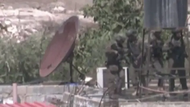 ヨルダン川西岸地区ジェニンの建物の屋根の上にいるイスラエル兵の画像
