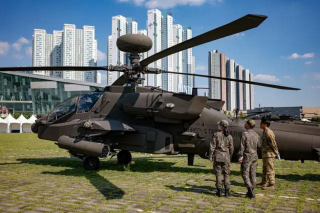 Soldados em frente a helicóptero militar