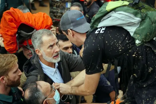 スペイン国王フェリペ6世（左）と、洪水対策の遅れに怒る住民（3日、スペイン東部バレンシア州パイポルタ）