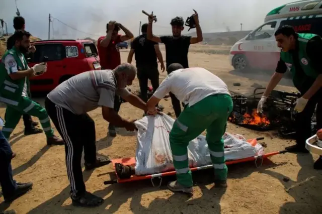 Paramédicos transportam os corposplataforma betanodois jovens palestinos cuja motocicleta foi atacada perto da fronteira entre a Faixaplataforma betanoGaza e Israel