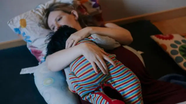 Seorang ibu hamil memeluk boneka dalam kursus pra-kelahiran di Rumah Bersalin "Prima Luce", Turin, Italia