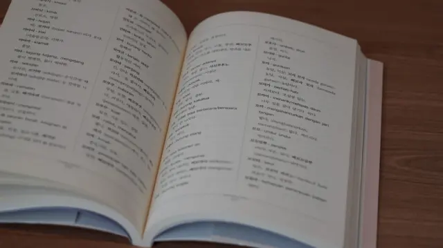Kamus bahasa Cia-Cia dalam posisi terbuka, menunjukkan halaman berisi kosa kata bahasa Cia-Cia dan terjemahannya dalam aksara Hangeul.