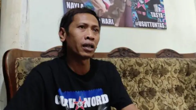 Devi Athok Yulfitri di depan foto dua mendiang putrinya, yang tewas bersama ibu mereka dalam tragedi Kanjuruhan di Malang, Jawa Timur, pada 1 Oktober 2022.