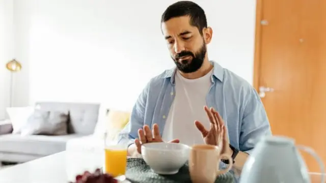 బ్రేక్ ఫాస్ట్ చేయడానికి కుర్చీలో కూర్చున్న వ్యక్తి