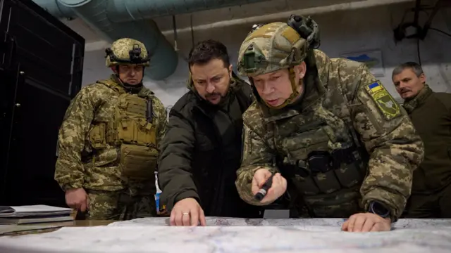 2023 йилда Украина ҳарбийлари позицияларидан бирига ташриф буюрган Президент Володимир Зеленский Қуруқлик қўшинлари қўмондони, генерал-полковник Олександр Сирскийнинг сўзларини тингламоқда.