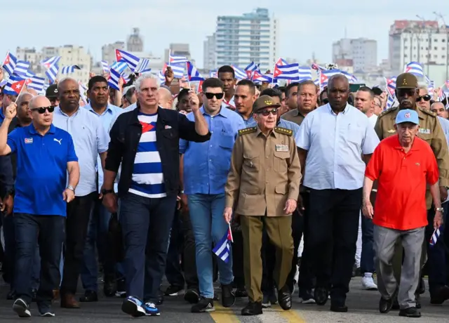 El presidente de Cuba, Miguel Díaz-Canel (segundo a la izquierda), y el expresidente cubano Raúl Castro (segundo a la derecha) pasan frente a la embajada de Estados Unidos mientras marchan con un grupo de dirigentes cubanos a lo largo del paseo marítimo de La Habana.