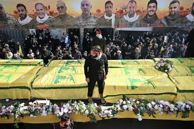 Warga yang membawa bendera dan poster Hizbullah berkumpul untuk menghadiri upacara pemakaman anggota Hizbullah yang tewas dalam serangan Israel di Lebanon selatan, di Nabatieh, Lebanon, 21 April 2026. (SUMBER FOTO: Elif Öztürk/Anadolu via Getty Images)