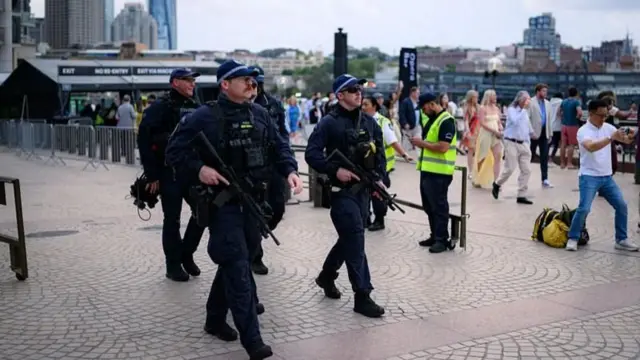 シドニー市内を、重装備の警官が歩いている。周囲には年越しイベントに向かうとみられる人々がいる