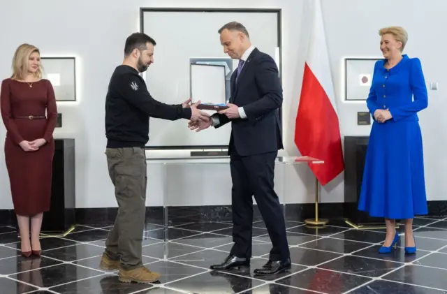 Дуда вручает орден Зеленскому, по бокам стоят их жены.