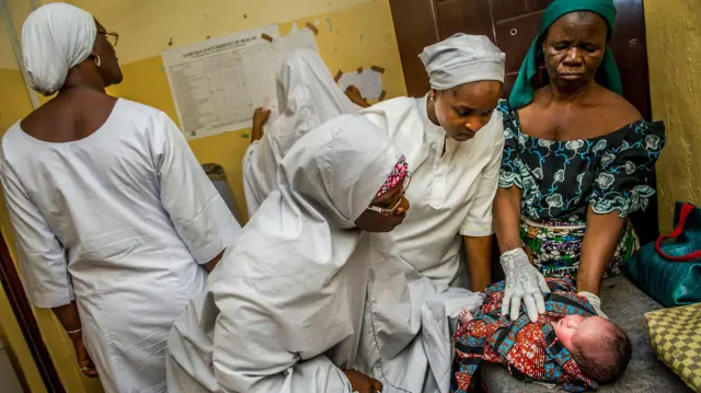 Midwives dey examine newborn baby for Women and Children Hospital in Gusau for Nigeria, dem deliver di baby through c-section. 