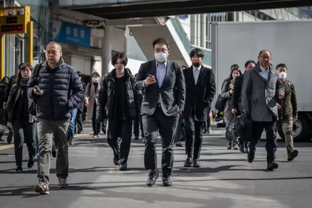 People walk through the Shinjuku area of Tokyo on March 15, 2024. 