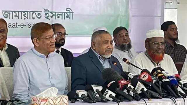 জামায়াতে ইসলামীর তিনজন কেন্দ্রীয় নেতা একটি সংবাদ সম্মেলনে বসে আছেন