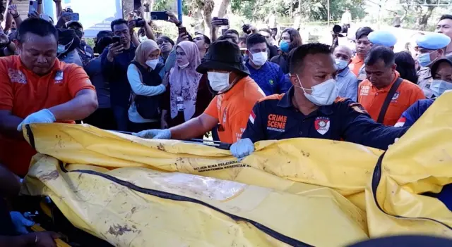 Petugas memindahkan jasad Afif Maulana ke dalam mobil ambulan saat proses ekshumasi di Padang, Sumatera Barat, Kamis (8/8/2024).