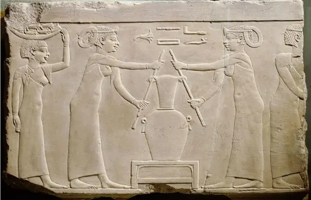 نقش بارز يظهر نساء يعملن كخادمات يعصرن الزنابق في معصرة لاستخراج الزيت لاستخدامه في العطور في مصر القديمة. الأسرة السادسة والعشرون في تاريخ مصر القديمة، في سنوات 664-525 قبل الميلاد.
