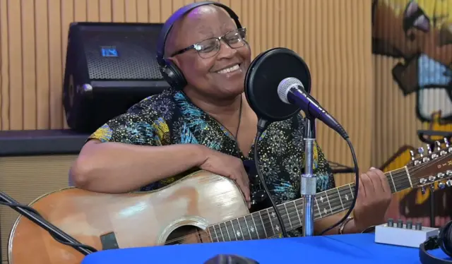 Afrika Nova yambaye amarori, ariko aravugira kuri micro, afise n'igitari