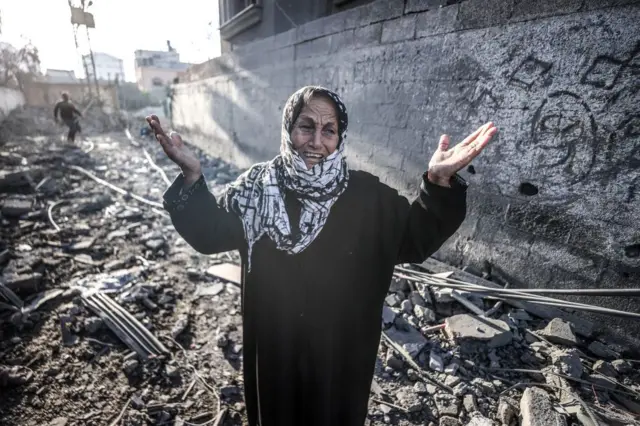 Một phụ nữ Palestine đứng trước đống đổ nát của các tòa nhà sau cuộc tấn công của quân đội Israel vào trại tị nạn Nuseirat ở trung tâm Dải Gaza,07/11/2024