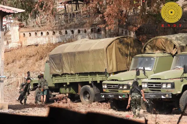 ရပ်ထားတဲ့ စစ်ကားသုံးစီးကို အကာအကွယ်ယူကာ ပစ်ခတ်ဖို့ပြင်ဆင်နေတဲ့ သေနတ်ကိုင်ထားတဲ့ ကရင်နီတော်လှန်ရေးတပ်ဖွဲ့ဝင် ၃ ဦးကိုတွေ့ရစဉ် 