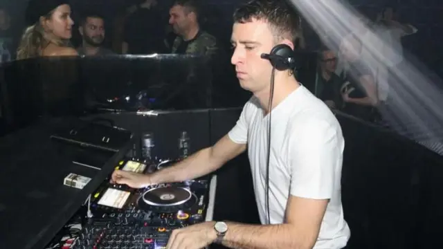 El DJ Jack Revill durante una sesión de música, manejando una consola de música.