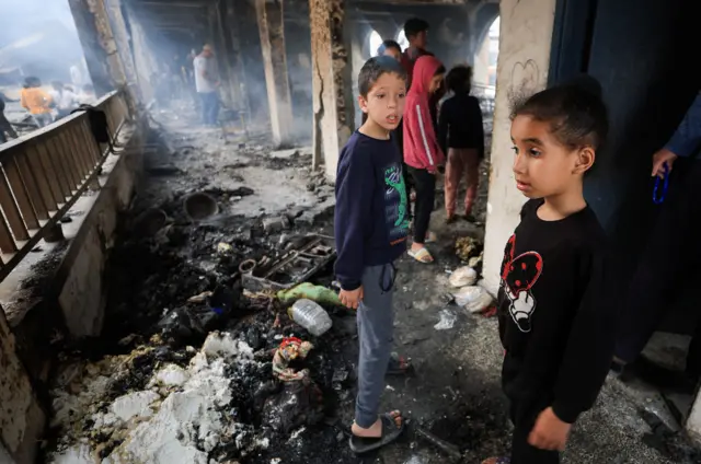 Two children inspect the damage to a school "Jaffa" Which was sheltering displaced people, after an Israeli raid, in Gaza City, April 23, 2025