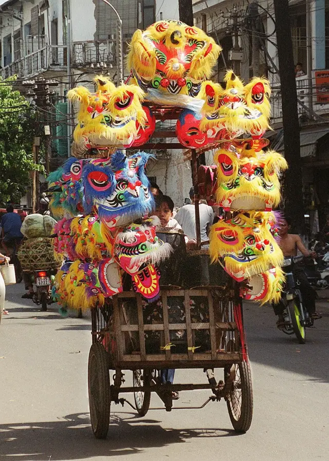 Một người bán dạo mặt nạ lân sư rồng tại Chợ Lớn trước Tết Canh Thìn 2000