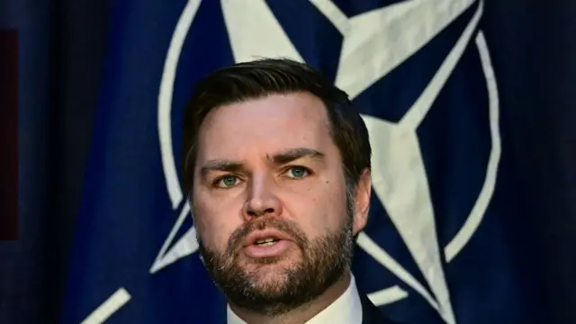 Віцепрезидент США Джей Ді Венс виступає на тлі логотипа НАТО.
