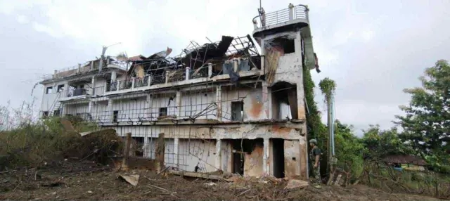 လေကြောင်းဗုံးထိမှန်ပြီး အမိုးလန်ကော ပျက်စီးနေတဲ့ သုံးထပ်အဆောက်အအုံ