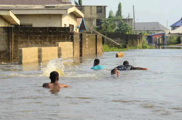 Des nigérians qui nagent dans la rue lors des inondations