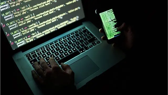 ኮምፒውተር እና ሞባይል የያዘ ሰው ምስል