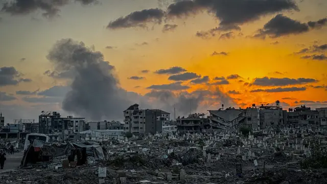 Разрушенные здания, дым на заднем плане.