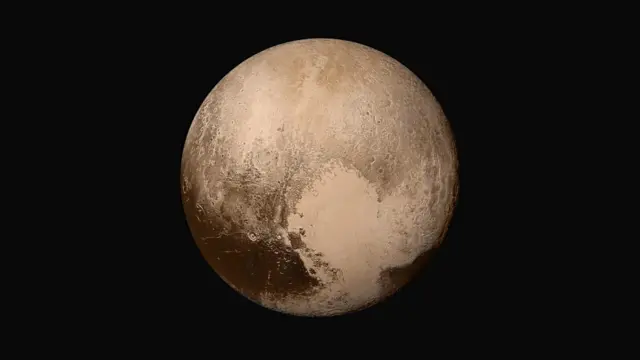 Pluto is seen as a brownish sphere against a black background, with darker and lighter coloured areas on its surface.