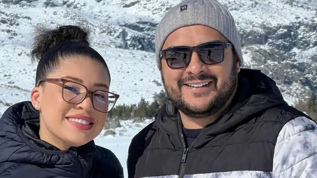 Casal sorrindo para foto na neve