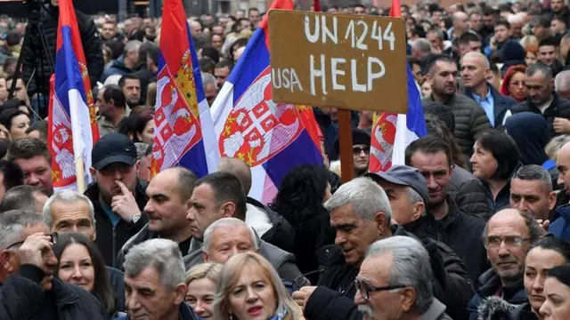 Десетине људи на протесту са српским заставама и транспарентом 'УН 1244 УСА ХЕЛП'