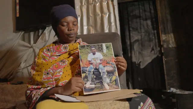 Mama wa muathiriwa wa maandamano ya Juni 2024 akiwa ameshikilia picha ya mtoto wake aliyeuawa