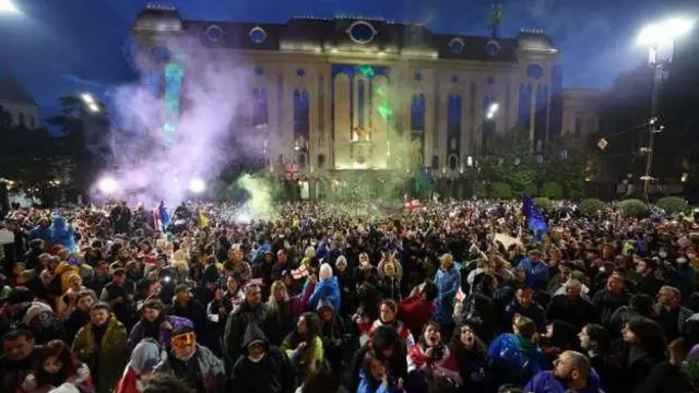 معترضان در برابر ساختمان پارلمان در تفلیس پس از تصویب قانون نفوذ خارجی که آن را مشابه قانونی در روسیه می‌خوانند