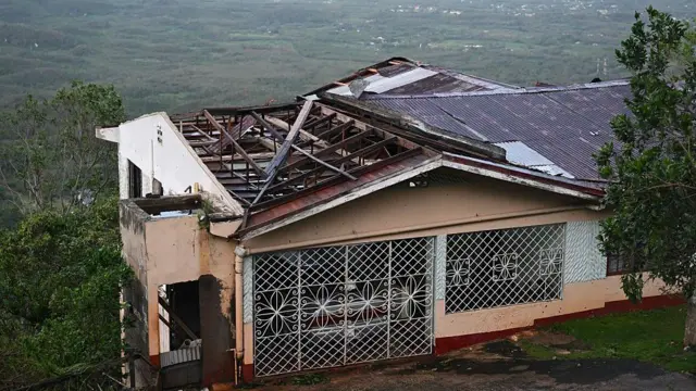 Дом с поврежденной крышей после урагана «Мелисса» в Манчестере, Ямайка, 28 октября 2025 года.